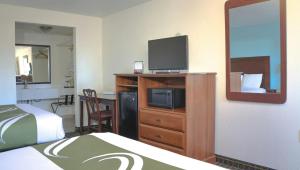 a hotel room with a bed and a tv on a dresser at Chippewa Motel Mount Pleasant in Mount Pleasant