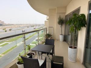 a balcony with a table and chairs and a highway at Al Raha Beach modern 1 bedroom near AD airport in Abu Dhabi