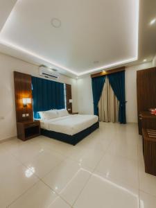 a bedroom with a bed and a blue window at شقق أونيسن للشقق المخدومة Onsen Serviced Apartments in Buraydah