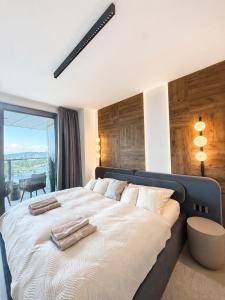 a bedroom with a large bed with a large window at Eurovea Tower, 27th floor apartment, free parking in Bratislava