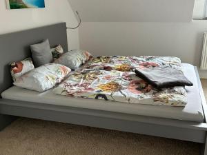 ein Bett mit einer geblümten Tagesdecke und Kissen darauf in der Unterkunft Falltor Living in Rees
