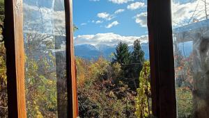 a window with a view of the mountains at El Cielo in El Bolsón