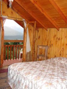a bedroom with a bed in a wooden cabin at El Cielo in El Bolsón