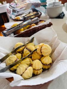 a basket of cookies with tongs on a table at Pousada Dona Elza in Monte Verde