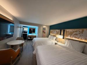 a hotel room with two beds and a table at Harbor Bay Inn in Costa Mesa