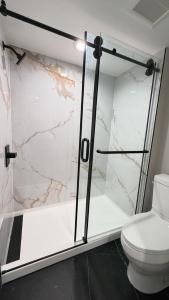 a bathroom with a shower and a toilet at Harbor Bay Inn in Costa Mesa +3 photos