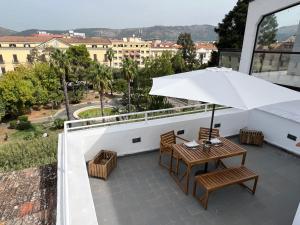 a balcony with a table and an umbrella at Terrazza Vanvitelli in Caserta