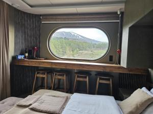 a room with a bed and a window with stools at Econest Aparan in Aparan