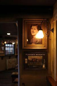 ein Bild einer Frau an einer Wand mit einem Licht in der Unterkunft Tigh Mary Donals Bar & Rooms at Whitegates in Killarney