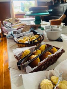 a table with several baskets of food on it at Pousada Dona Elza in Monte Verde