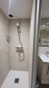 a shower in the corner of a bathroom at Oyonnax Bellignat Appart Hotel in Bellignat +55 photos
