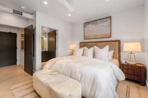 a large white bedroom with a large bed and a stool at Refined Big Sky Luxury Condo in Big Sky