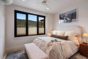a bedroom with a bed and two windows at Refined Big Sky Luxury Condo in Big Sky