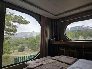 a bedroom with a bed and two large windows at Econest Aparan in Aparan