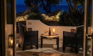 a table with two chairs and a candle on a patio at Barracuda Suite Sea View & Dinner Experience in Ischia Town +24 photos