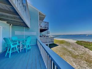 a blue house with a deck with a table and chairs at Sandcastle Townhomes #24 in Navarre