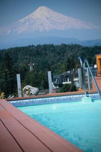 Ein Swimmingpool mit einem Berg im Hintergrund in der Unterkunft Hotel Pucón Indómito in Pucón