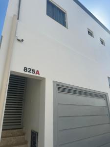 a white building with a garage door and a window at Apartamento aconchegante em Irecê in Irecê