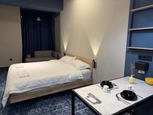 a bedroom with a bed and two tables in it at Smile Residence Bishkek in Bishkek