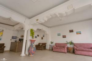 a living room with two pink chairs and a vase at Home Hotel Dahab in Dahab