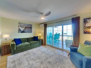 a living room with a green couch and blue chairs at Sandcastle Townhomes #24 in Navarre