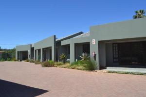 un bâtiment avec une route en briques rouges devant lui dans l'établissement Be At Home Guesthouse, à Klerksdorp