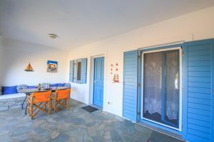 a patio with a table and chairs and a door at Anemos in Drios