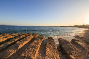 a group of rocks on a beach near the water at Anemos in Drios