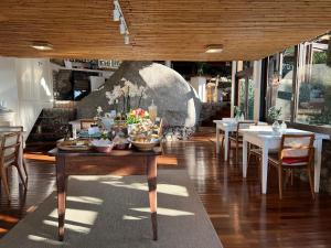 a dining room with tables and chairs and a large rock at Pousada Quinta do Bucanero in Imbituba