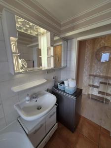 a bathroom with a sink and a mirror at Deichherz - Skyline & Wohlfühlatmosphäre inklusive Parkausnahmegenehmigungsschein in Bremerhaven +23 photos