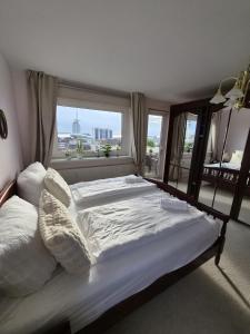 a large bed in a bedroom with a large window at Deichherz - Skyline & Wohlfühlatmosphäre inklusive Parkausnahmegenehmigungsschein in Bremerhaven