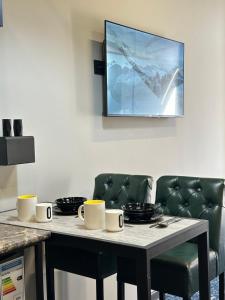 a table and chairs with cups and plates on it at Smile Residence Bishkek in Bishkek +14 photos