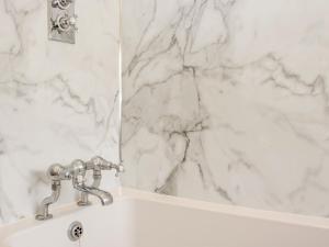 a white bathroom with a sink and a mirror at Upper Frogpool Cottage in Crediton