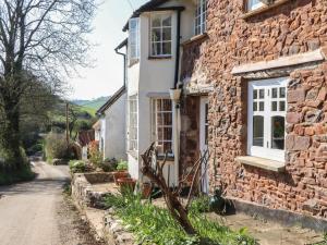 a stone house on a cobblestone street at Upper Frogpool Cottage in Crediton