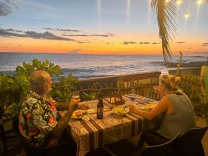 a man and woman sitting at a table on the beach at Blue Maalu Resort in Ambalangoda