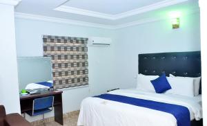 a hotel room with a bed and a desk with a computer at P Meridian Hotels in Awoyaya