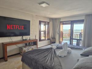 a hotel room with a netflix sign on the wall at Luxury Oceanfront House - Beachfront - Pool in Aquiraz
