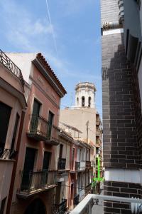 a city street with buildings and a clock tower at Ceramic Rooms Boutique Hostel in Villareal