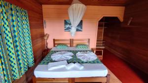 a bedroom with two beds in a wooden cabin at Roça Monte Forte in Neves