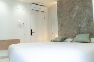 a bedroom with a large white bed with two pillows at Ceramic Rooms Boutique Hostel in Villareal