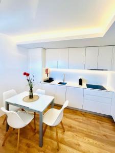 a kitchen with white cabinets and a table and chairs at Loft City Center Viana in Viana do Castelo