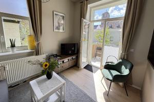 a living room with a tv and a chair and a window at Ferienwohnung Truding in Stralsund