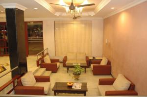 un vestíbulo con sofás, sillas y una mesa en Hotel Saradharam en Chidambaram