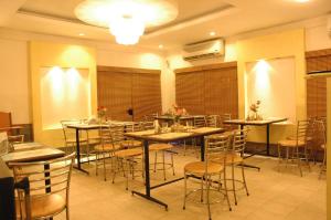 un restaurante con mesas y sillas con flores. en Hotel Saradharam en Chidambaram