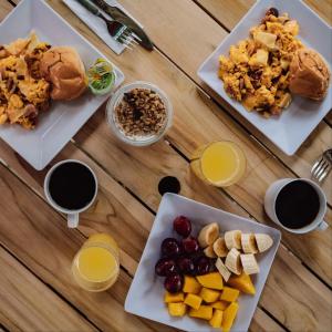 a wooden table with three plates of food and drinks at Oasis Tolú Hotel Boutique in Tolú