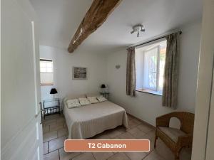 a bedroom with a bed and a window and a chair at L'Arc en Ciel in Gréoux-les-Bains