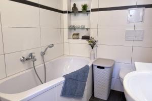 a bathroom with a tub and a toilet and a sink at Ferienwohnung Truding in Stralsund +26 photos