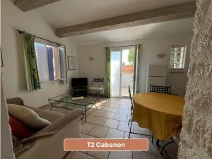 a living room with a couch and a table at L'Arc en Ciel in Gréoux-les-Bains