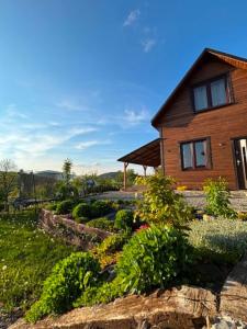 a wooden house with a garden in front of it at Sowie wzgórze in Krynica Zdrój