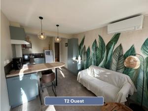 a kitchen and living room with a large leaf mural on the wall at L'Arc en Ciel in Gréoux-les-Bains